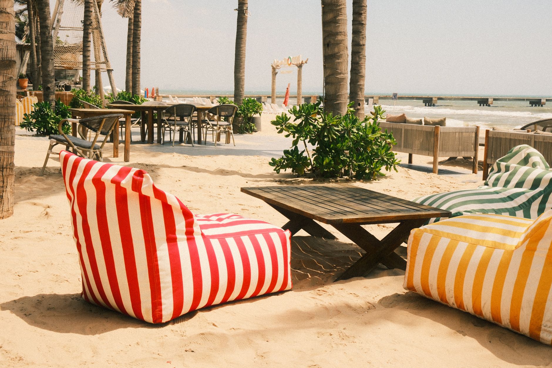 Lounge chairs and skincare product displays set up under umbrellas at a beach-side beauty event